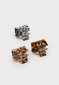 Set of three hair clips: black and white marbled, dark tortoiseshell, and lighter tortoiseshell. Plastic material with textured grips.