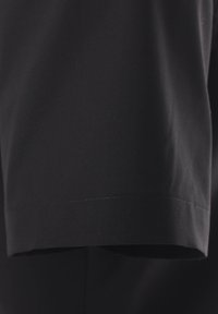 Zwart T-shirt met korte mouwen, gemaakt van een gladde stof, met een rechte zoom en nette stiksels. Geen patronen of versieringen aanwezig.