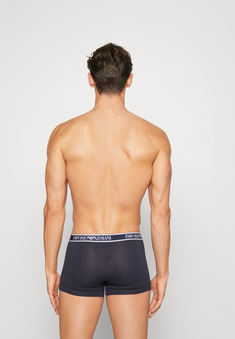 Boxer-briefs gris foncé en matériau élastique avec une ceinture logo. Le design présente une coupe ajustée et une texture lisse.
