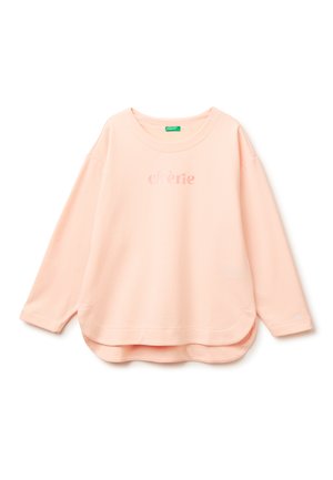 Hellrosa langärmliges Sweatshirt mit abgerundetem Saum und dem leicht dunkler rosa gedruckten Wort "chère" auf der Brust.
