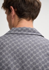Gray shirt with a subtle circular pattern, featuring a classic collar and a soft texture. The design is clean and modern.