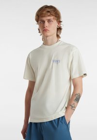 Cremfarbendes Baumwoll-T-Shirt mit kurzen Ärmeln, Rundhalsausschnitt und einem grafischen Logo auf der linken Brust. Legerer Schnitt und weiche Textur.