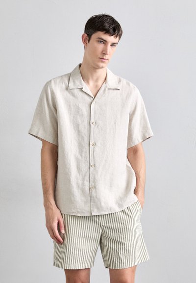 Linen short-sleeve shirt in light beige with a button-down front. Paired with striped shorts in muted tones, featuring a straight-cut design.