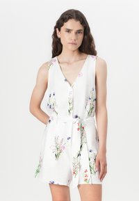 Rompers bianco con motivo floreale, scollo a V, senza maniche, vita cinturata e vivaci dettagli floreali multicolore su tutto il tessuto.