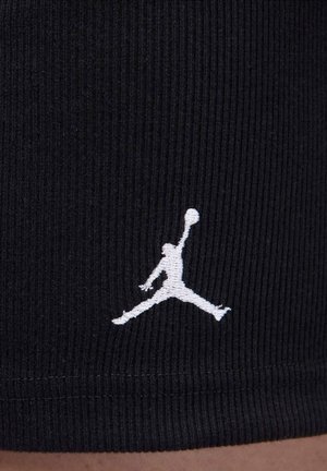 Czarne szorty z prążkowanej tkaniny z białym haftowanym logo Jumpman blisko brzegu. Teksturowana powierzchnia z dopasowanym krojem.