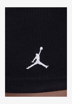 Shorts in tessuto nero a coste con logo Jumpman bianco ricamato vicino all'orlo. Superficie strutturata con design aderente.