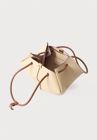 Μπεζ ορθογ ώνια γυναικεία τσάντα με καφέ χερούλια με κορδόνι, χρυσό κούμπωμα και απαλό ροζ εσωτερικό επένδυση, εμφανίζεται ανοιχτή σε λευκό φόντο.