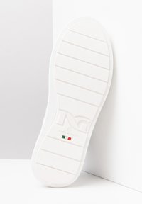Semelle de chaussure en caoutchouc blanc avec des rainures horizontales, logo en relief et texte "FABRIQUÉ EN ITALIE". Présente un accent avec le drapeau italien.