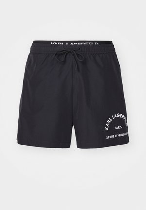 Bañador negro hecho de material liviano, con una cinturilla elástica con cordón y acentos de marca en blanco en la parte frontal.