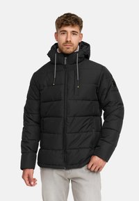 Giacca a vento nera con zip frontale, cappuccio regolabile e design trapuntato. Presenta tasche laterali e cordoncini a contrasto.