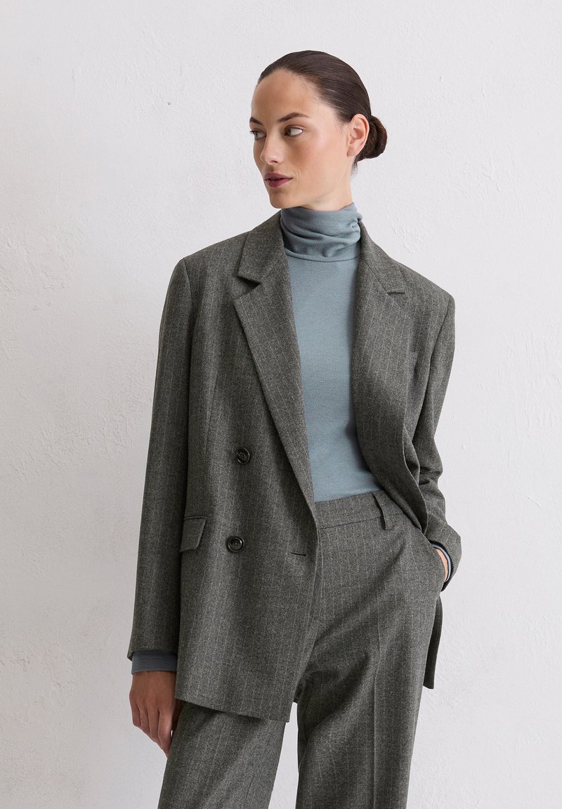 Grijze pinstripe blazer met een dubbelreeks ontwerp, zwarte knopen en notch revers, gecombineerd met een lichtblauwe coltrui.