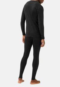 Zwart geribbeld thermopaket bestaande uit een longsleeve top en aansluitende broek, gemaakt van zachte stof, met een comfortabele pasvorm rond de polsen en enkels.