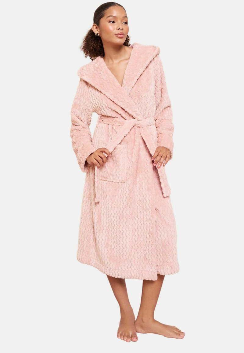 Ružový, štruktúrovaný župan so šálovým golierom, pásekovým opaskom a dvoma prednými vreckami. Tkanina má vlnitý vzor, ktorý vytvára mäkký vzhľad.