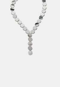 Sølvv necklace med cirkulære skiver arrangeret i en V-form, glossy overflade, varierende størrelser og en central dråbe detalje, der øger den visuelle interesse.
