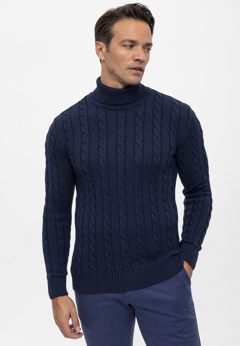 Dunkelblauer Rollkragenpullover aus gestricktem Material mit Kabelmuster. Die gerippten Bündchen und der Saum sorgen für Struktur und Textur.