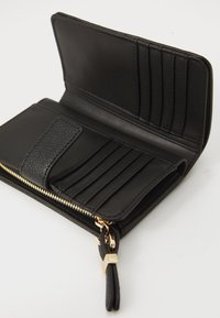 Black wallet, leather material, zip closure, multiple card slots, smooth texture, gold-tone hardware, minimalist design, compact shape.