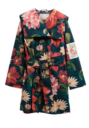 Παλτό με λουλουδένιο σχέδιο και ζώνη σε σκούρα πράσινα, κόκκινα και ροζ αποχρώσεις με μεγάλα λουλούδια, που παρουσιάζει το λογότυπο Barbour Farm Rose στο στήθος και το μανίκι.