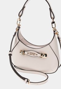 Hellegraue synthetische Handtasche mit goldener Hardware, geschwungener Form und abnehmbarem Tragegurt mit schwarzem Rand und Logo-Detail.