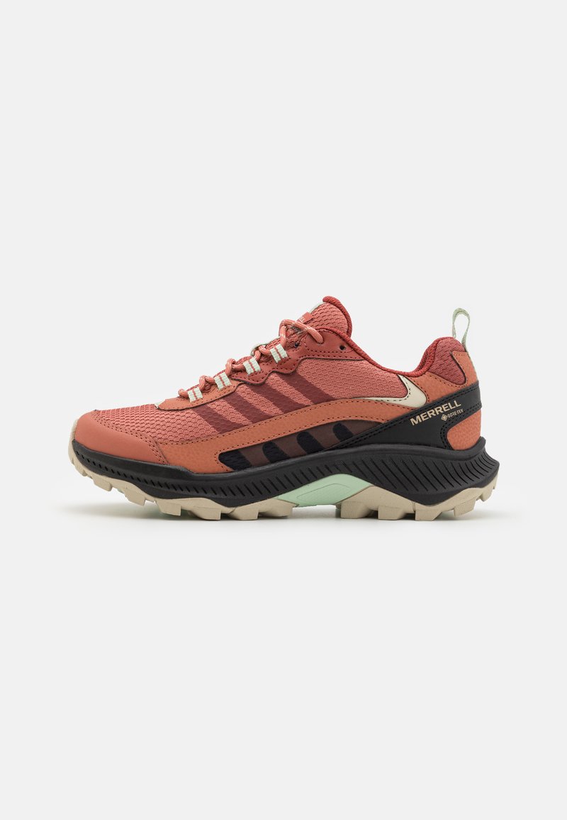 Merrell tursko i terrengskosko i korallfarge og svart, med en teksturert mesh overdel, forsterket tåhette og robust gummisåle med gripemønstre.