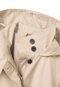 Beige Trenchcoat mit hohem Kragen, ausgestattet mit einem Reißverschluss vorne und drei schwarzen Knöpfen. Glattes Gewebe mit einem leichten Glanz.