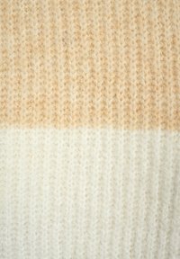 Strickstoff in einem Farbverlauf von hellbeige bis cremigem Weiß, mit einem strukturierten Muster aus ausgeprägten vertikalen Stichen und einer weichen, flauschigen Textur.