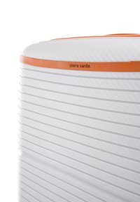 Maleta blanca con surcos horizontales, acentuada por una franja naranja. Cuenta con un acabado texturizado que muestra el nombre de la marca "Pierre Cardin."