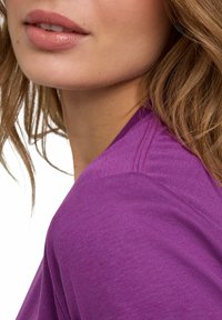 Paarse katoenen blend top met een zachte textuur, voorzien van een ronde halslijn en subtiele schoudernaaddetails. Gladde afwerking en aansluitend ontwerp.
