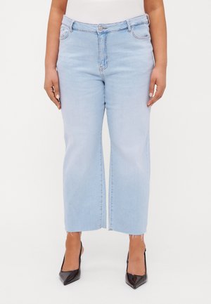 Lyseblå vide jeans med knappelukking, frontlommer, frynset kant og myk denimtekstur. Kombinert med svarte spisse hæler.