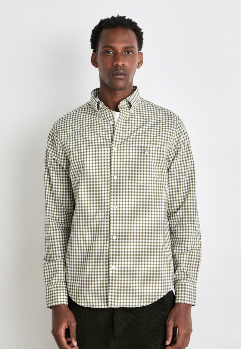 Camicia a quadri verde e bianca con colletto. Vestibilità slim e maniche lunghe, con una piccola etichetta logo sul lato sinistro del petto.
