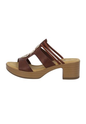 Braune Leder-Sandale mit offenem Zehenbereich, gekrümmtem Absatz, Kreuzbanddesign und dekorativen Metallelementen im Obermaterial. Strukturierte Holzsohle.