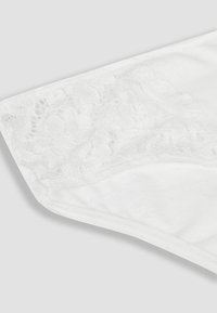 Mutandine bianche con sovrapposizione in pizzo in vita, tessuto liscio e design senza cuciture. Il delicato motivo floreale in pizzo aggiunge texture.