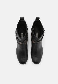 Bottines en cuir noir avec une texture lisse, des zips latéraux et des accents décoratifs marron. Conception avec bout rond et hauteur de cheville.