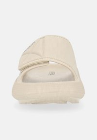 Sandal in beige con tomaia texturizzata e cinturino regolabile. Presenta una soletta imbottita e una suola decorata per una maggiore aderenza.