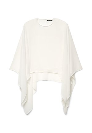 Weiße asymmetrische Bluse im Poncho-Stil mit weiten, fließenden Ärmeln und rundem Ausschnitt, vor weißem Hintergrund präsentiert.