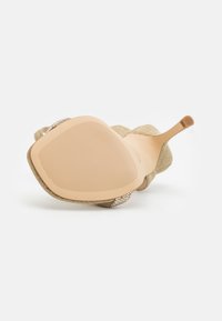 Sandale à talon haut avec une semelle nude, un talon stiletto fin, et une tige en tissu ornée de petites perles décoratives.