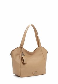 Sac cabas en cuir beige avec double poignée, un petit porte-clés suspendu et une plaque métallique avec le logo de la marque à l’avant.