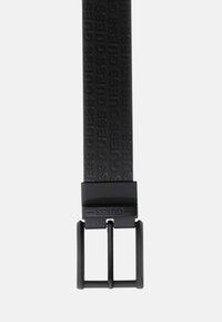 Cintura in pelle nera con motivo in rilievo "GUESS", fibbia in metallo con finitura nera opaca, forma piatta, superficie liscia.