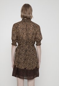 Vestido con estampado de leopardo, cuello alto fruncido, mangas abullonadas y dobladillo en capas. Tela ligera y transparente con cintura ajustada.