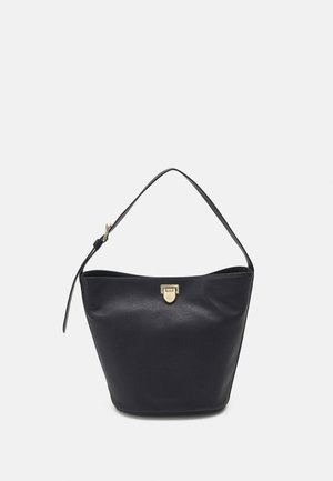 Sac seau en cuir noir avec une bandoulière unique réglable et une petite fermeture dorée au centre en haut.