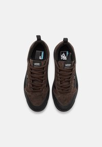 Brązowe sneakersy Vans z zamszową i siateczkową cholewą, czarnymi akcentami, okrągłym noskiem, gumową podeszwą i wyściółką w kołnierzu, z wiązaniem i metkami z logo.