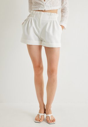 Pantalones cortos blancos de talle alto con cintura elástica, bolsillos laterales y dobladillo enrollado. Hechos de una tela suave, que presenta una textura lisa.