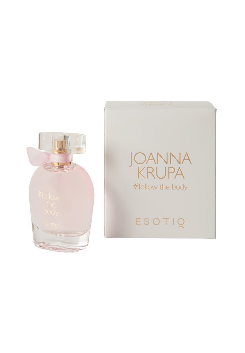 Przezroczysta butelka na perfumy z delikatnie różowym płynem, o okrągłym kształcie, z przezroczystą zakrętką i przewiązana różową wstążką. Zapakowana w białe pudełko.