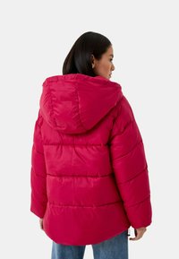 Giubbotto puffer fucsia con cappuccio, caratterizzato da un design a cuciture orizzontali, polsini elasticizzati e orlo con cordino. Texture liscia e lucida.