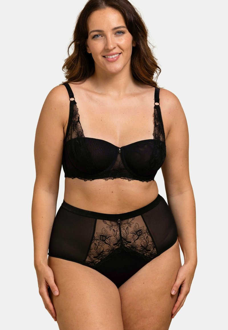 Ensemble de lingerie noire avec un mesh transparent et des accents en dentelle florale. Le soutien-gorge offre un support sous-bust, tandis que les culottes taille haute présentent des détails similaires.