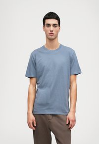 Ljusblå bomulls-T-shirt med rund hals och korta ärmar, med en jämn textur och en avslappnad passform. Utesluter mönster och detaljer.