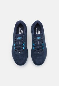 Baskets de sport bleu foncé en maille respirante avec des surfaces texturées, dotées d'accents et de lacets bleus, et d'une semelle rembourrée.
