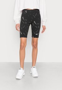 Svarta cykelshorts i ett slätt, elastiskt material, med ett spritt grått Nike-logomönster och en vit Nike-logotyp på vänster ben.