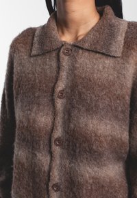 Cardigan in lana marrone con colletto, caratterizzato da una morbida texture, un motivo a gradiente e tre bottoni marroni sul davanti.