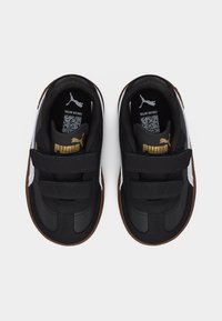 Παιδικά παπούτσια Puma ασπρόμαυρα με διπλές λουρίδες Velcro και καφέ σόλες, από ψηλά σε λευκό φόντο.