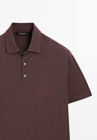 Burgundy polo shirt lavet af glat stof, med krave, tre-knaps lukning og korte ærmer med subtile syninger.